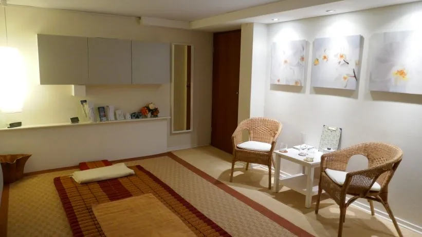 Ruhebereich der Praxis mit Thai-Massagematte und Sitzecke