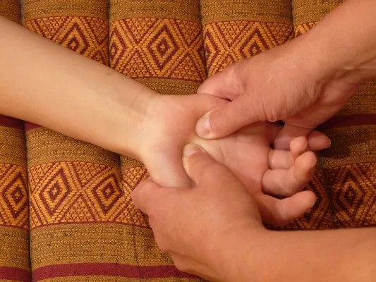 Druckpunkt-Massage an Handgelenk und Fuß mit den Daumen